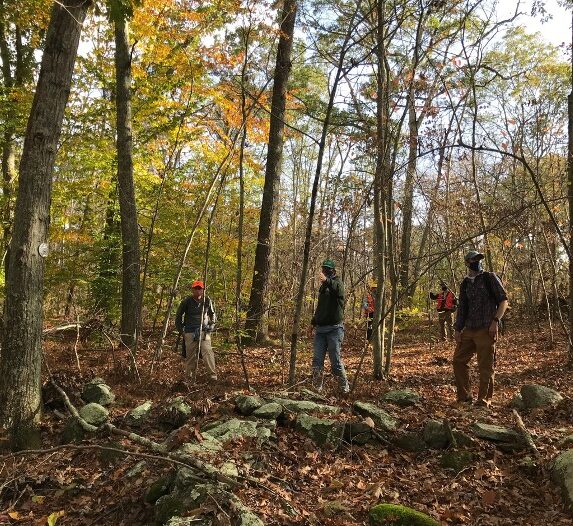 Three people taking a tour of the Mohegan State Forest.